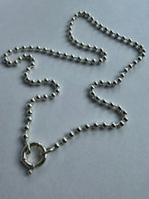 Load image into Gallery viewer, A silver ball chain necklace with a circular ring clasp, laid out on a plain light gray surface.
