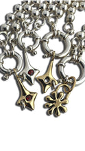 Load image into Gallery viewer, Close-up of a silver and gold necklace with various charms on a white background
